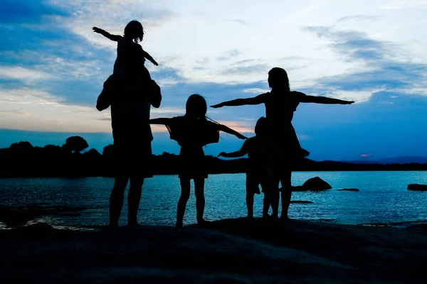 Famille heureuse au bord de la mer sur fond de silhouette nature — Photo