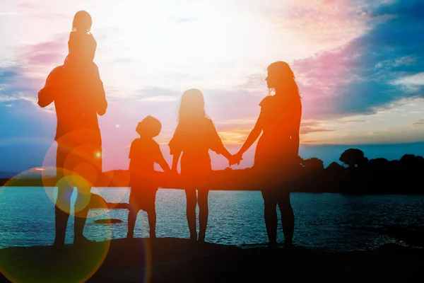 Deniz kenarında mutlu bir aile, doğanın siluetinde. — Stok fotoğraf