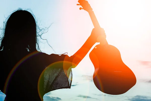 Lycklig flicka med ukulele vid havet på naturen Silhouette bakgrun — Stockfoto