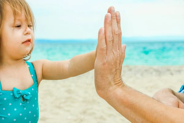 Mooie handen van een gelukkige ouder en kind door de zee in de natuur — Stockfoto