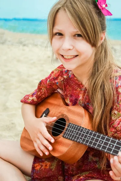 Criança feliz tocando guitarra pelo mar greece no fundo da natureza — Fotografia de Stock