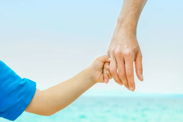 Belles mains d'un parent heureux et d'un enfant au bord de la mer dans la nature — Photo