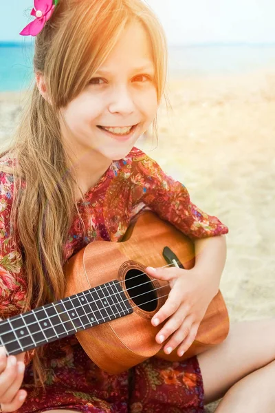 Criança feliz tocando guitarra pelo mar greece no fundo da natureza — Fotografia de Stock