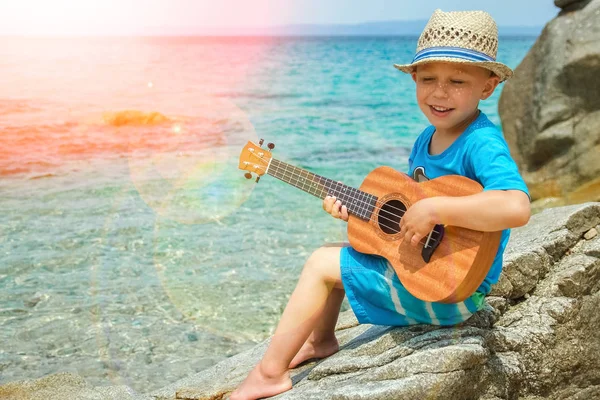 Glückliches Kind spielt Gitarre am Meer Griechenland auf Naturhintergrund — Stockfoto