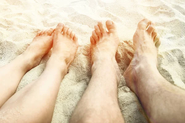 Mooie benen in het zand van de zee Griekse achtergrond — Stockfoto