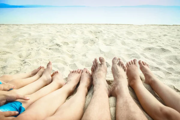 Hermosas piernas en la arena del fondo de la Grecia del mar —  Fotos de Stock