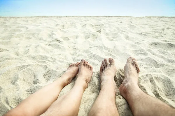 Mooie benen in het zand van de zee Griekse achtergrond — Stockfoto