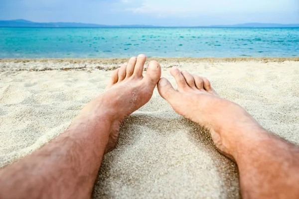 Mooie benen in het zand van de zee Griekse achtergrond — Stockfoto