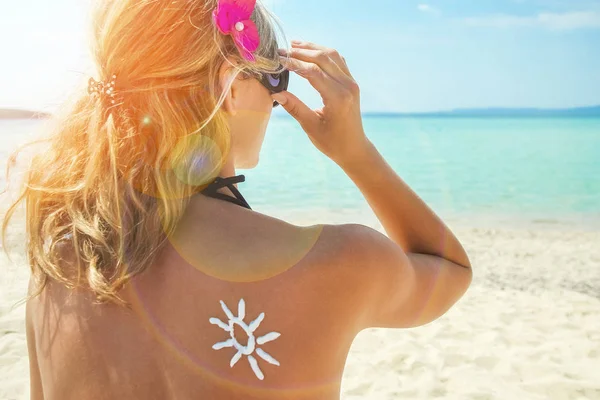 Šťastná dívka na moři s obrázkem slunce na zádech — Stock fotografie