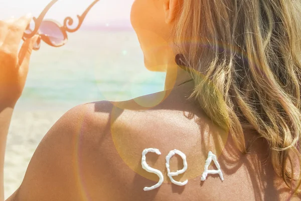 Gelukkig meisje op de zee met een foto van de zon op haar rug — Stockfoto