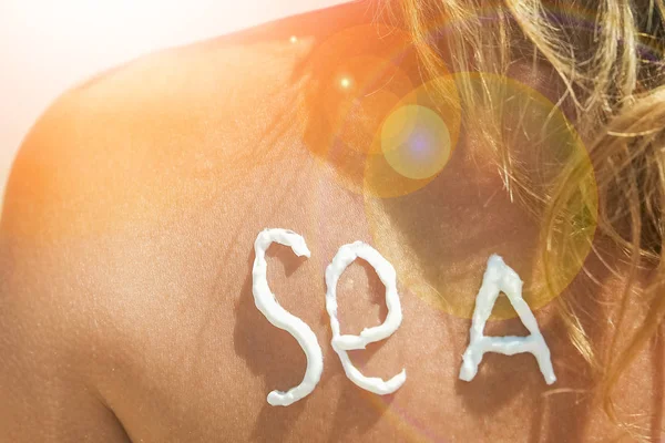 Счастливая девушка на море с изображением солнца на спине — стоковое фото