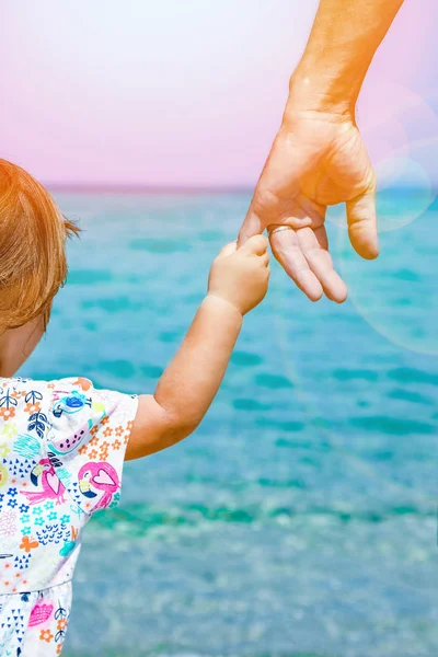 Manos de padres felices y el niño en el fondo de la Grecia del mar —  Fotos de Stock
