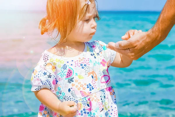Ruce šťastný rodič a dítě na moři řecké pozadí — Stock fotografie
