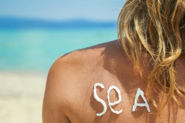Glückliches Mädchen auf dem Meer mit einem Bild der Sonne auf dem Rücken — Stockfoto