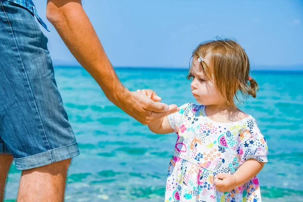 Manos de padres felices y el niño en el fondo de la Grecia del mar — Foto de Stock