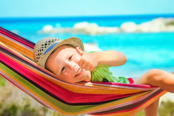 เด็กมีความสุขริมทะเลบนเปลญวนในกรีซพื้นหลัง — ภาพถ่ายสต็อก