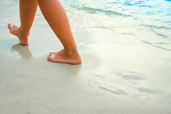 Mooie benen op het zand aan de Griekse zee — Stockfoto