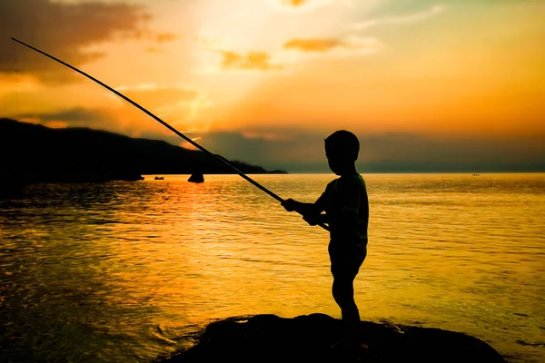 Pêche enfant heureux par la silhouette de la mer — Photo