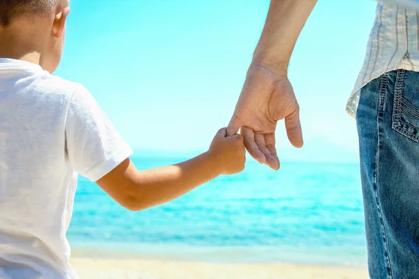 Pai feliz segura a mão de uma criança pelo mar grego na natureza — Fotografia de Stock