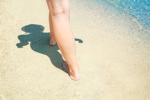Belle gambe sulla sabbia in riva al mare — Foto Stock
