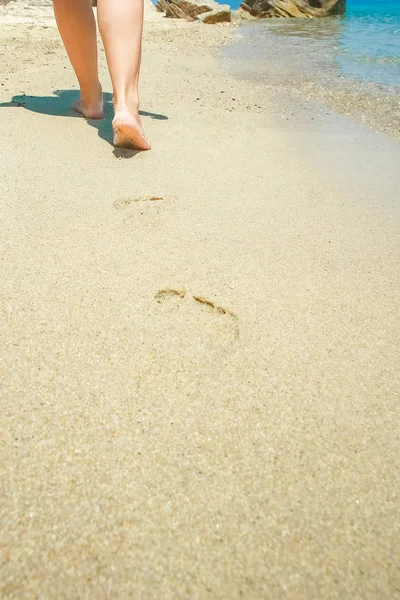 Hermosas piernas en la arena junto al mar —  Fotos de Stock
