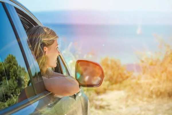 Glückliches Mädchen aus dem Auto auf See Griechenland Hintergrund — Stockfoto
