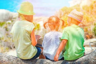 yunan deniz kıyısı arka planda oynayan mutlu çocuklar