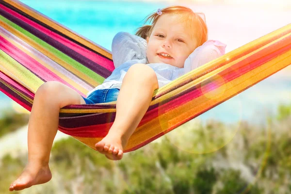 Gelukkig kind door de zee op hangmat in Griekenland achtergrond — Stockfoto