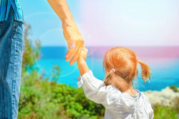 Manos de padres felices y el niño en el fondo de la Grecia del mar —  Fotos de Stock