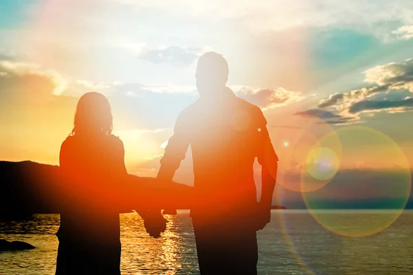 happy couple silhouette by the Greek sea on the shore background