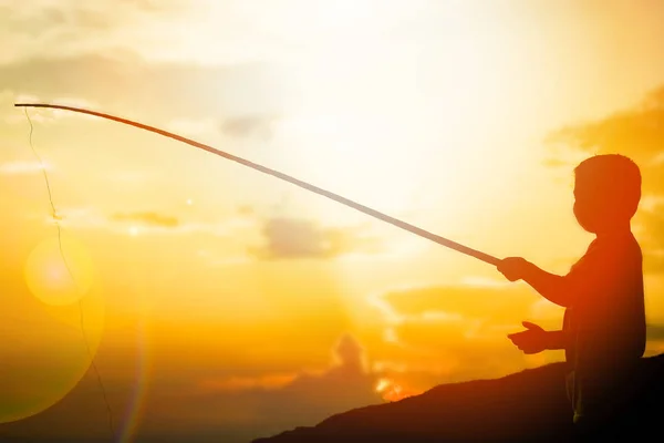 Feliz niño pescando por la silueta del mar —  Fotos de Stock