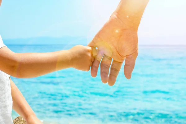 Lycklig pappa håller i handen på ett barn vid det grekiska havet i naturen — Stockfoto