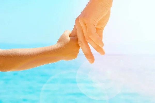 Mutlu baba, Yunan Denizi kıyısında bir çocuğun elini tutuyor. — Stok fotoğraf