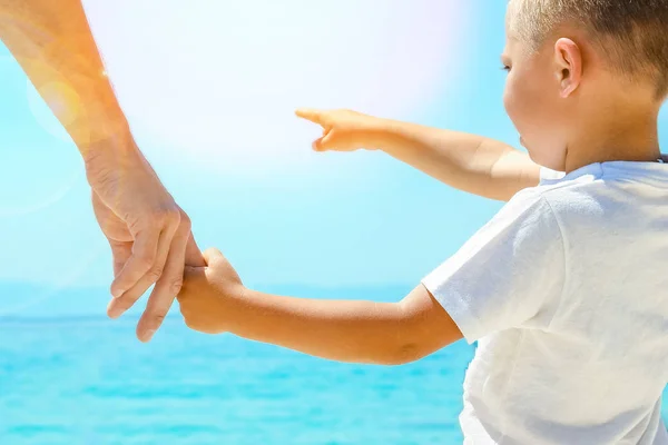 Feliz papá toma la mano de un niño por el mar griego en la naturaleza —  Fotos de Stock