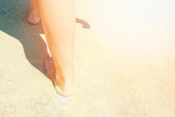 Belles jambes sur le sable au bord de la mer — Photo