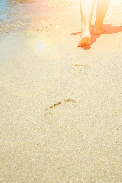 Mooie benen op het zand aan zee — Stockfoto