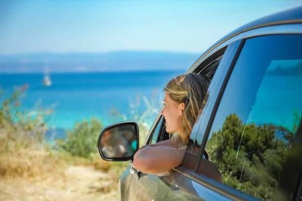 Glückliches Mädchen aus dem Auto auf See Griechenland Hintergrund — Stockfoto