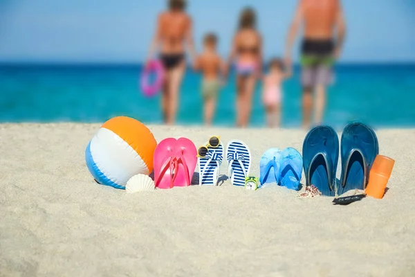 Familia feliz en el mar con zapatillas en el fondo de la naturaleza —  Fotos de Stock