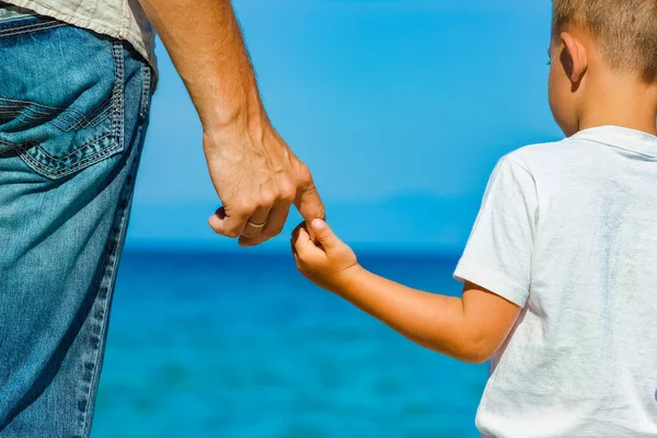 Feliz papá toma la mano de un niño por el mar griego en la naturaleza —  Fotos de Stock