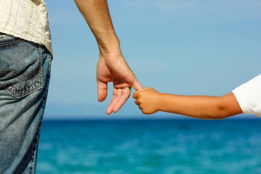 Üst çocuğun el sahilde tutar.