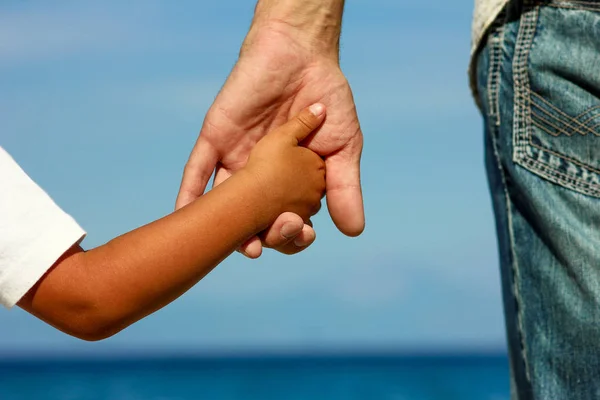 Le parent tient la main de l'enfant sur la plage — Photo