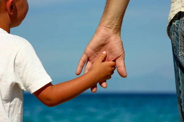 Der Elternteil hält die Hand des Kindes am Strand — Stockfoto