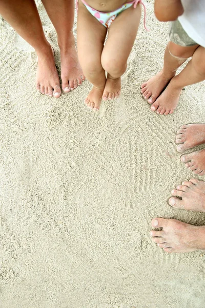 Familjen fötter i sanden på stranden — Stockfoto