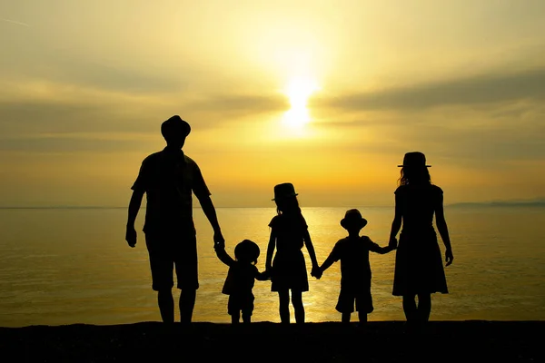 Familiensilhouette bei Sonnenuntergang am Meer — Stockfoto