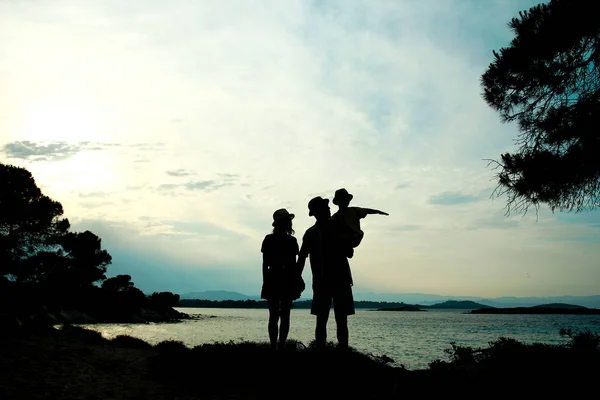 Silhouette familiale au coucher du soleil au bord de la mer — Photo