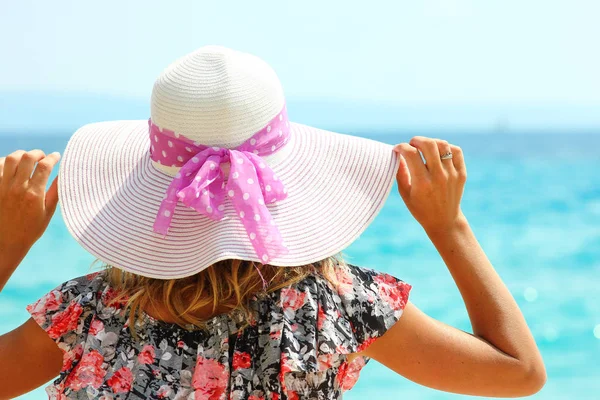 Jonge vrouw met hoed aan de kust — Stockfoto