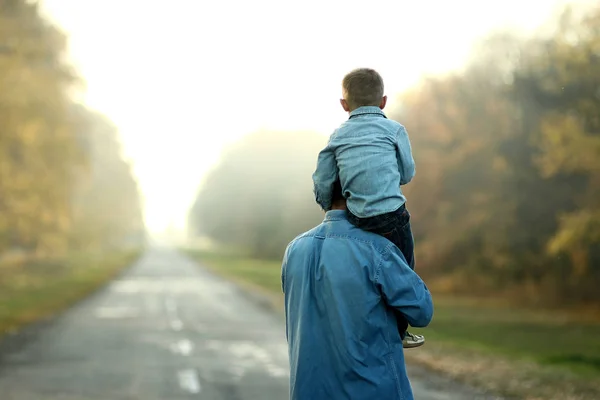 Vader en zoon lopen in de natuur — Stockfoto