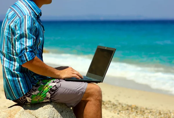 Homme avec ordinateur portable près de la mer — Photo