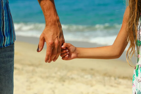 The parent holds the child's hand on the beach — Stock Photo, Image