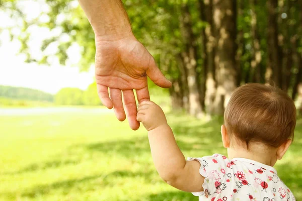 Руки счастливого родителя и ребенка в природе — стоковое фото